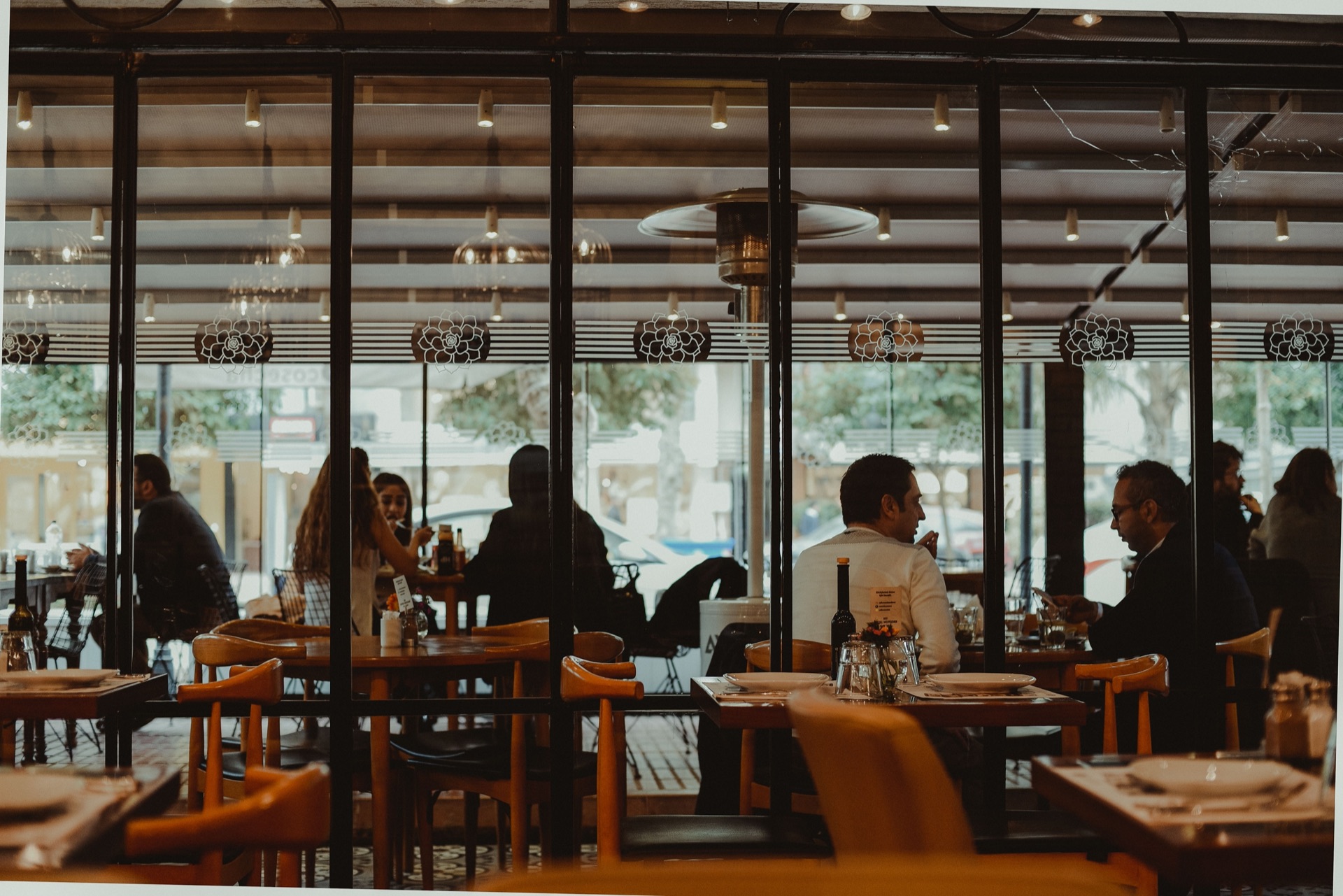 Guests dining at a busy restaurant with street-facing windows